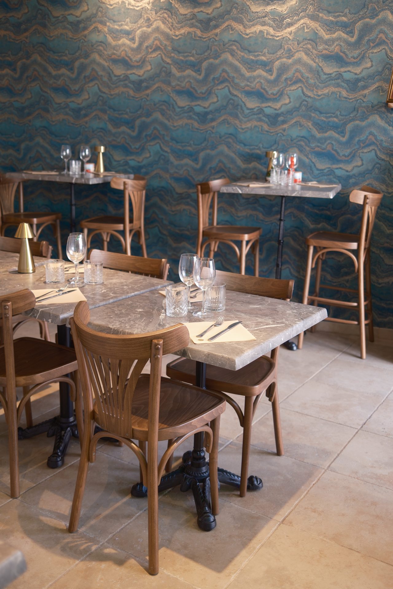 Chaises bistrot devant le papier peint bleu marbré